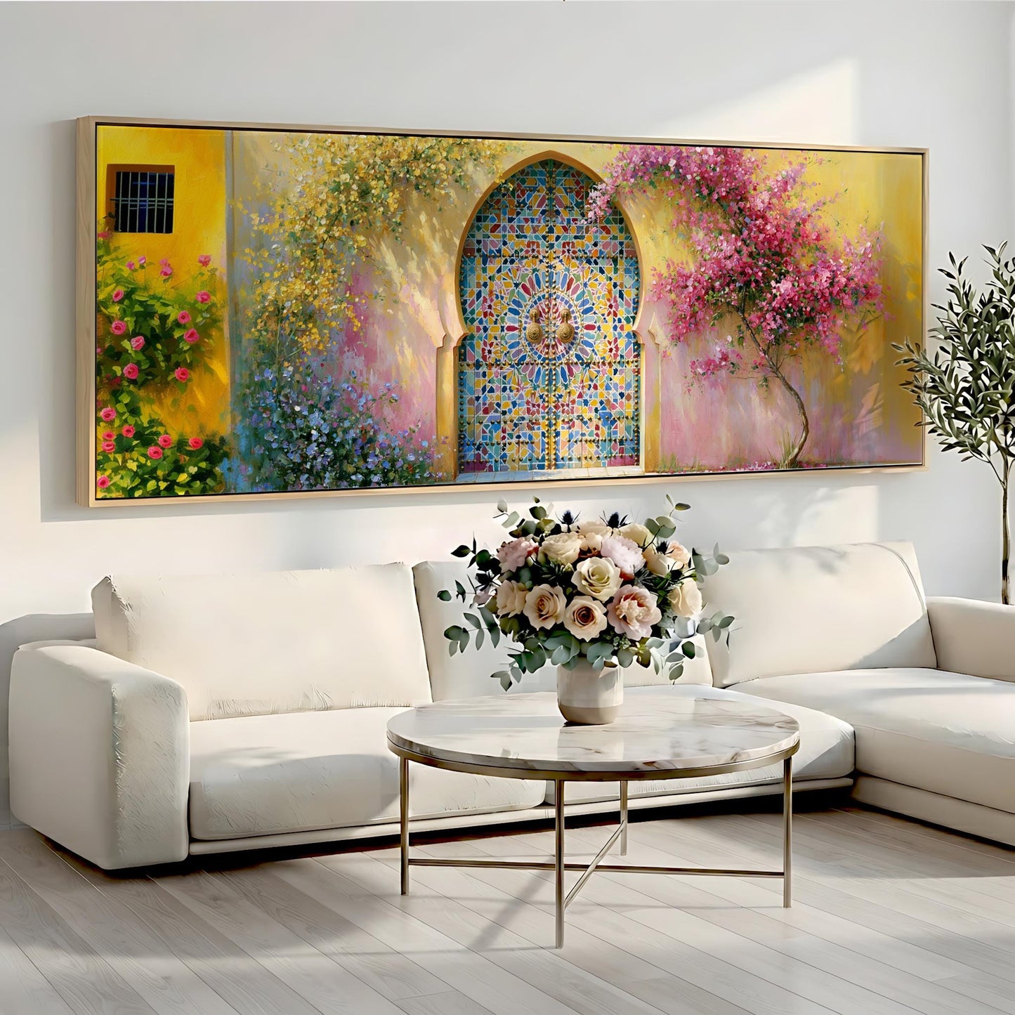 a large, colorful painting of a stained glass window above a white sofa with a vase of flowers on a coffee table in front of it.