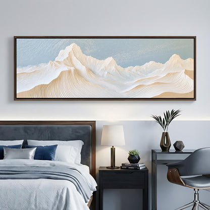 a large, framed painting of a mountain landscape hanging on a wall above a bed with a gray headboard.