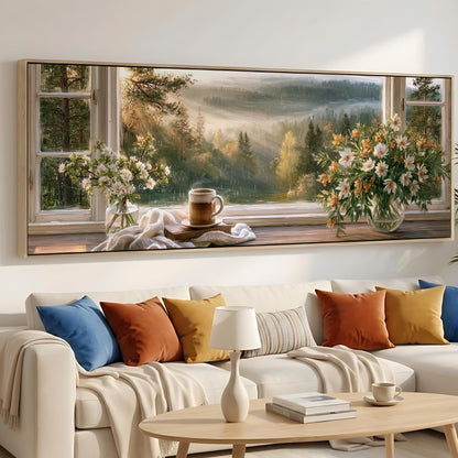 a serene living room with a large window overlooking a picturesque landscape. The window is adorned with two vases of flowers, one on each side, and a coffee mug on the windowsill. The room is furnished with a white sofa and a wooden coffee table, creating a cozy and inviting atmosphere.