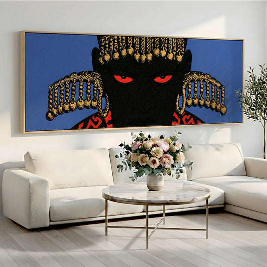 a large, colorful painting of a man's face with a black background and gold accents, hanging on a wall above a white sofa and a round coffee table with a vase of flowers.
