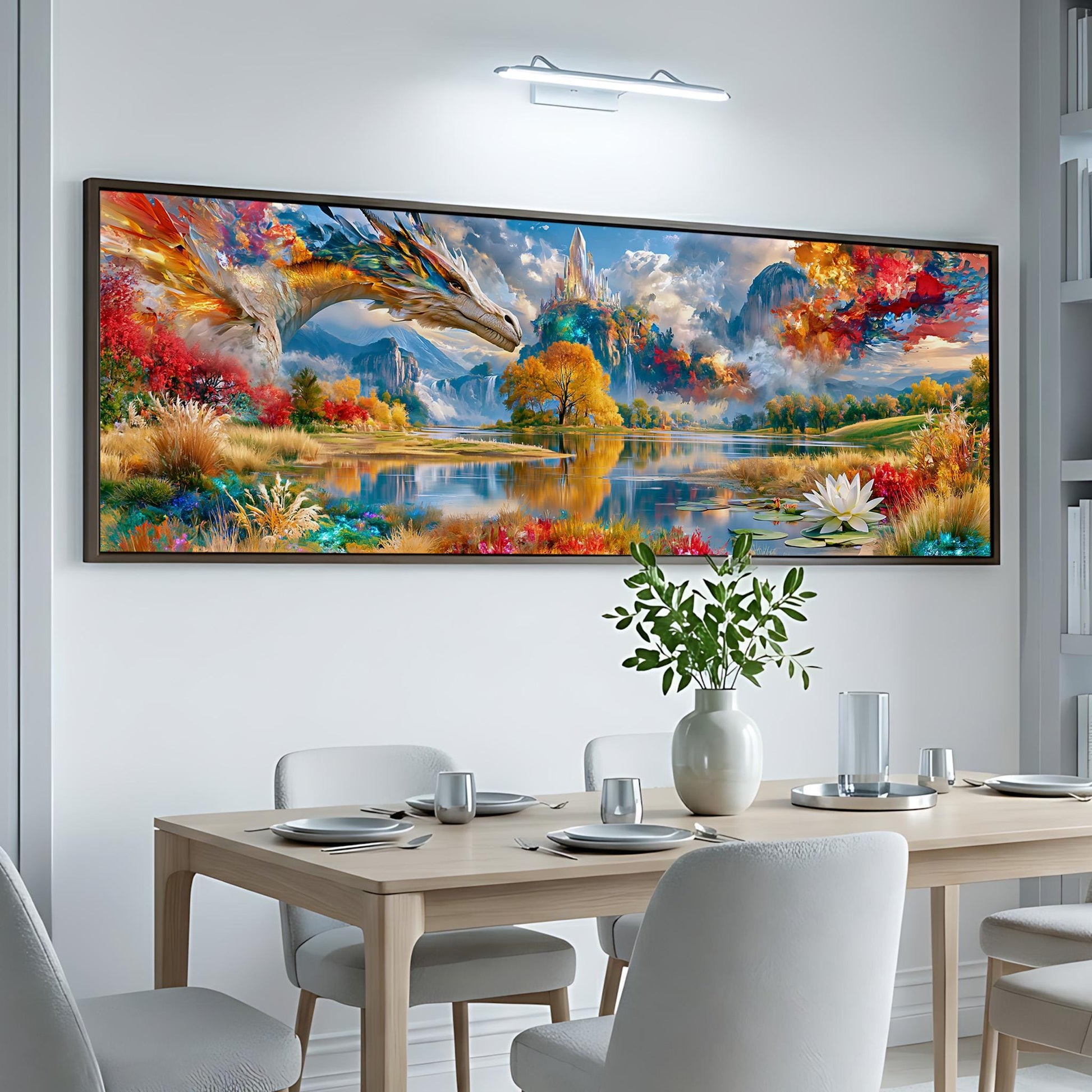 a large, colorful painting of a landscape with a dragon-like creature in the foreground, set against a serene body of water and mountains in the background. The painting is hung on a white wall above a dining table, which is set with plates, silverware, and a vase of flowers.