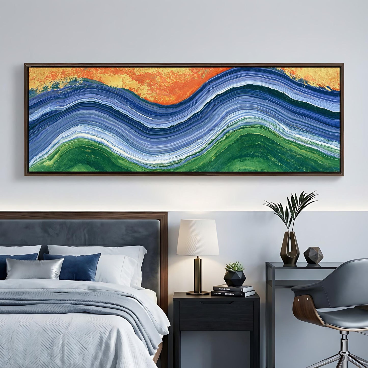 a large, colorful abstract painting hanging on a wall above a bed with a gray headboard. The painting has a vibrant mix of blue, green, orange, and white colors, creating a striking visual effect. The bed is neatly made with white linens and a gray headboard, and there is a nightstand with a lamp and a plant on it. A chair is also present in the room, suggesting a cozy and inviting living space.