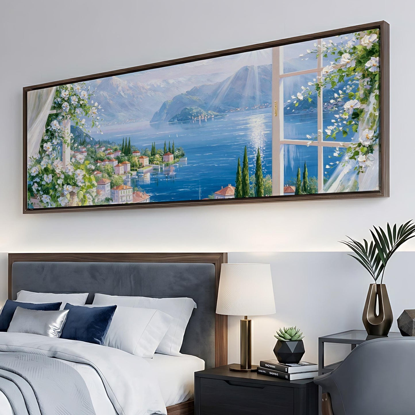 a large painting of a scenic landscape hanging on a wall above a bed with white bedding and a nightstand with a lamp.