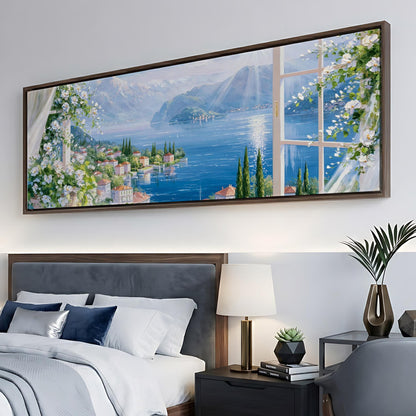 a large painting of a scenic landscape hanging on a wall above a bed with white bedding and a nightstand with a lamp.