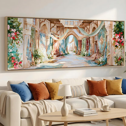 a large, colorful painting of an ornate, arched hallway with floral decorations hanging from the ceiling. The painting is displayed on the wall above a white sofa with colorful throw pillows.
