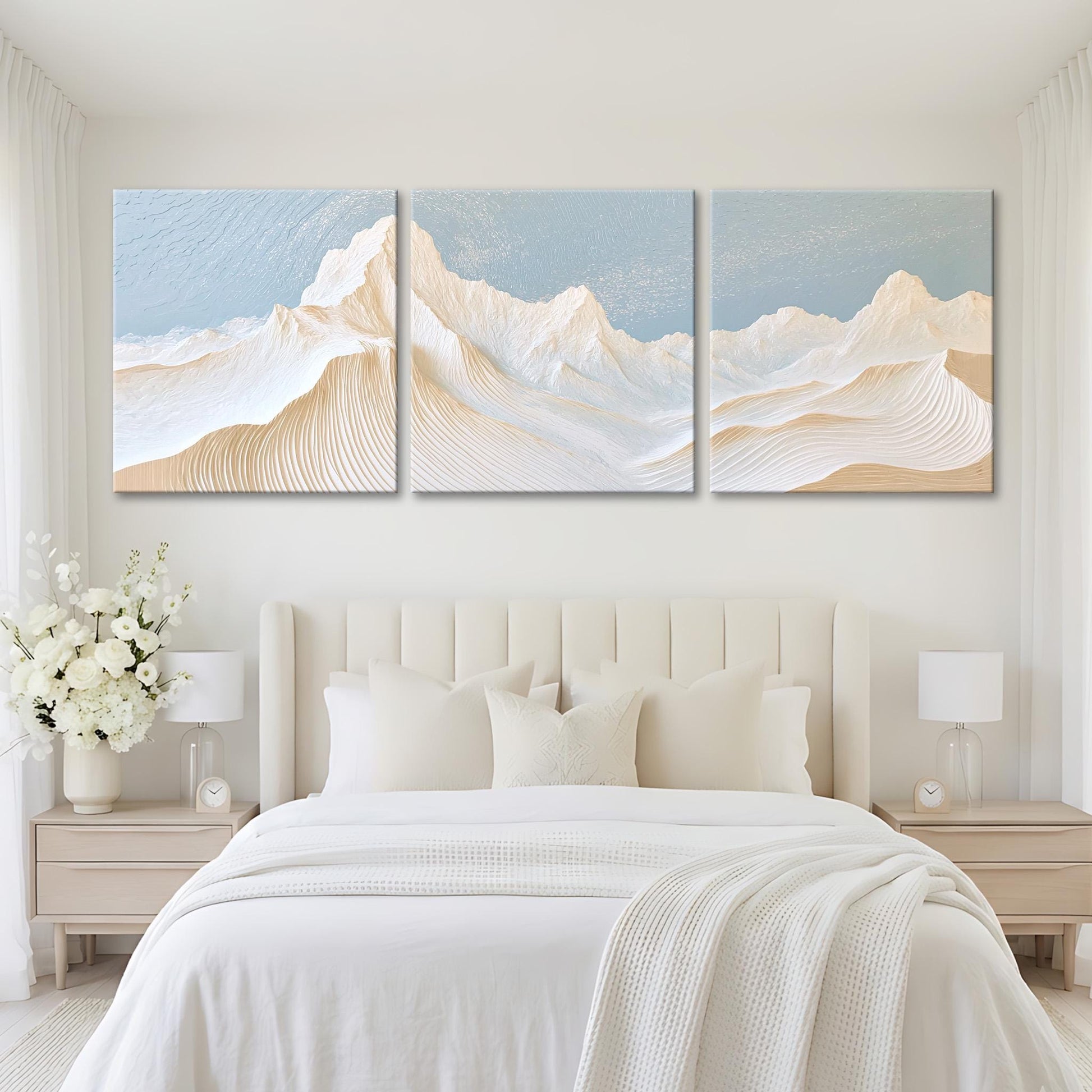 A serene bedroom with a large bed, white bedding, and a large painting of a mountain landscape above it.