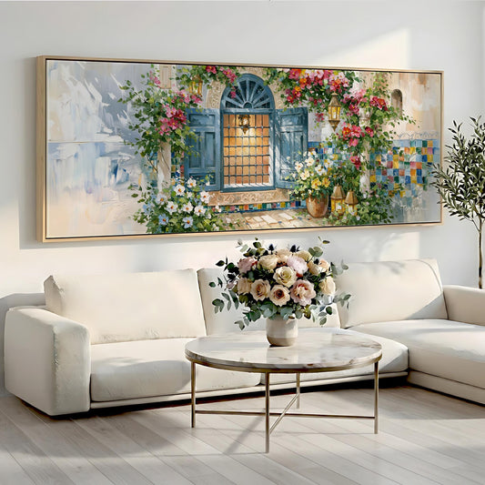 a large painting of a window with flowers and a door, hanging on a wall above a white sofa and a round coffee table.