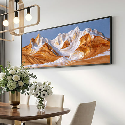 a large framed painting of a mountain landscape hanging on a wall above a dining table with a vase of white flowers.