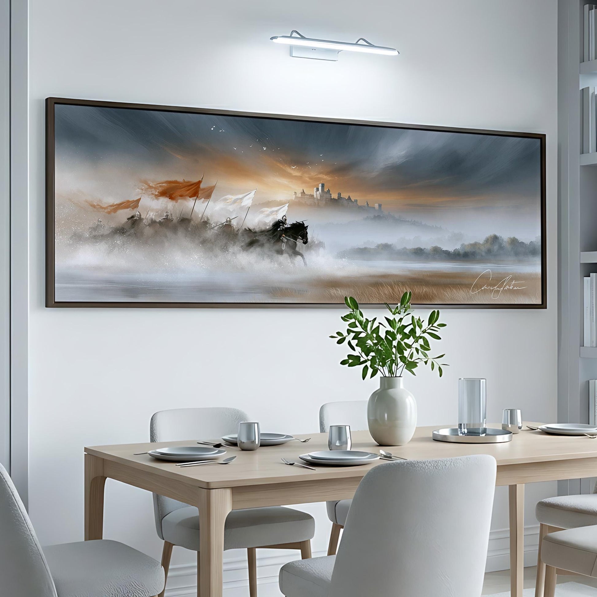 a large, framed painting of a serene landscape hanging on a white wall above a dining table set with plates, silverware, and a vase of greenery.
