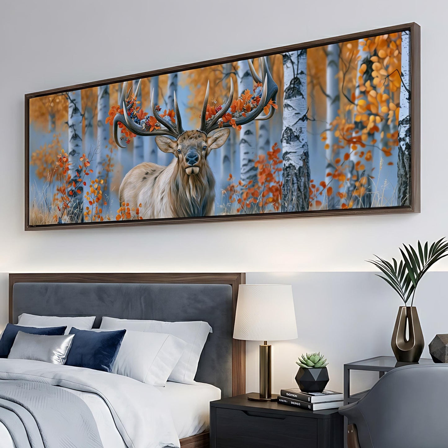 a large framed painting of a deer with antlers in a forest setting, hanging on a wall above a bed with white bedding.
