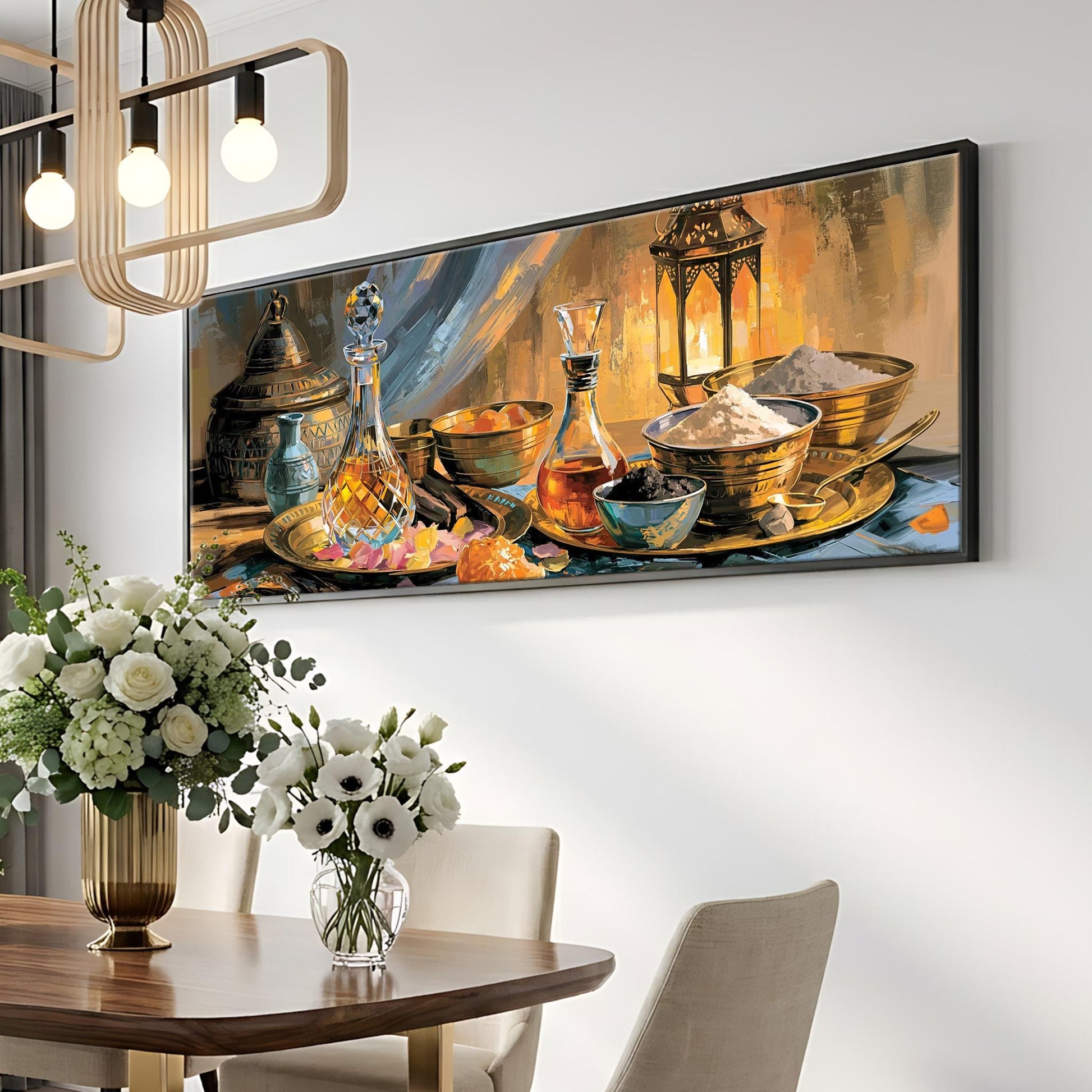 a dining room with a large painting of various bowls, vases, and bottles hanging on the wall above a wooden table. The table is set with a vase of white flowers and a bottle of wine. The room has a modern and elegant design, with a chandelier and a white wall providing a neutral backdrop for the colorful artwork.
