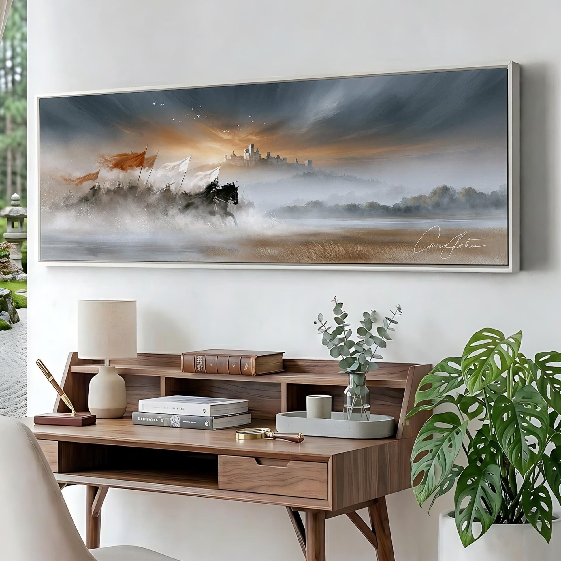 a large painting of a landscape with a horse and a castle in the distance, hanging on a wall above a wooden desk with a lamp, books, and a plant.