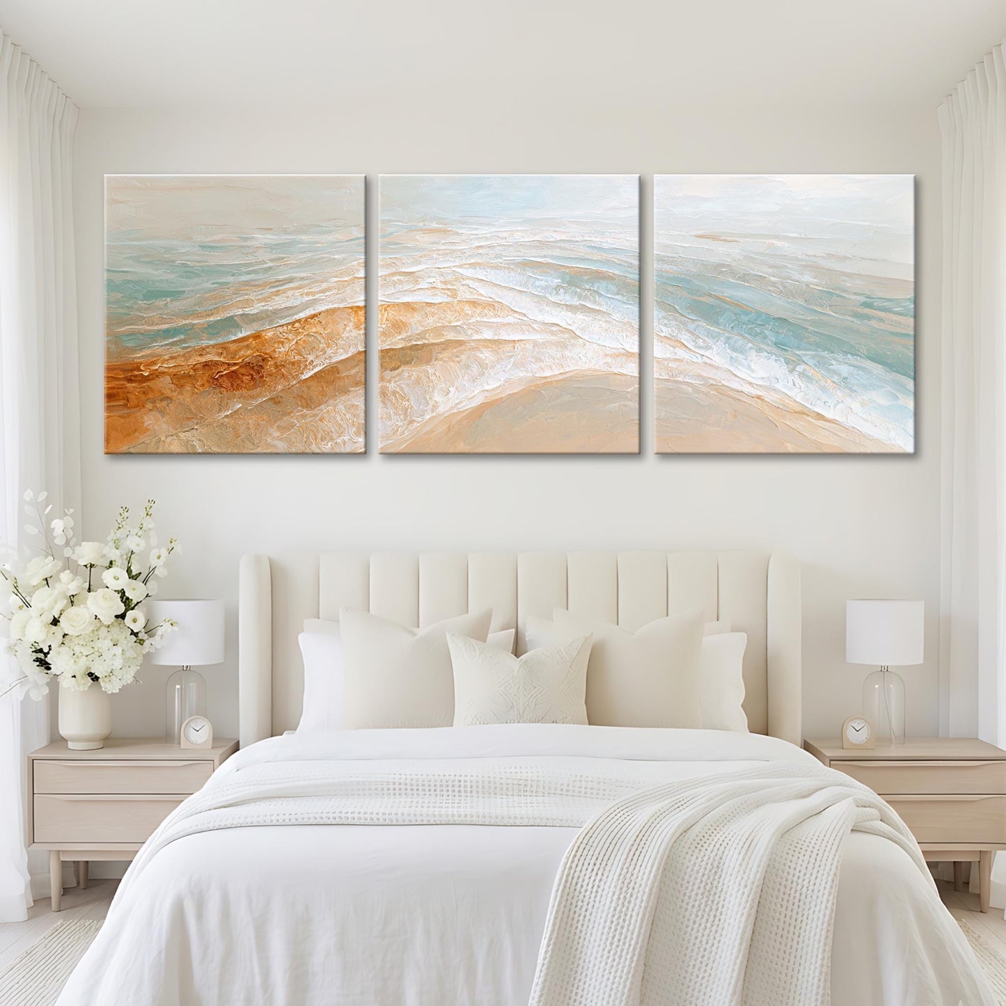 A modern bedroom with a large bed, white bedding, and a painting of a beach scene above it.