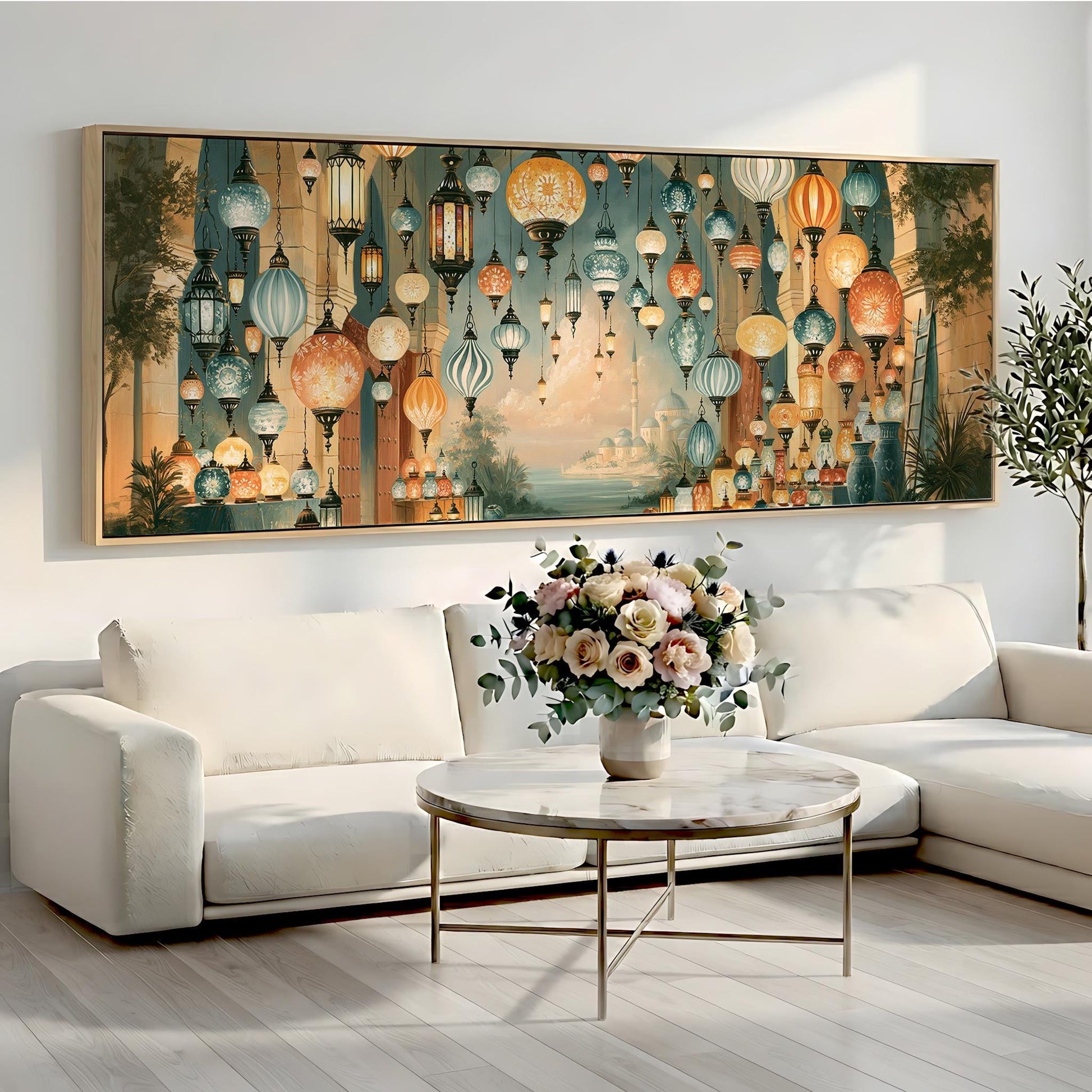 a large, colorful painting of hanging lanterns on a wall above a white sofa and a round coffee table with a vase of flowers.
