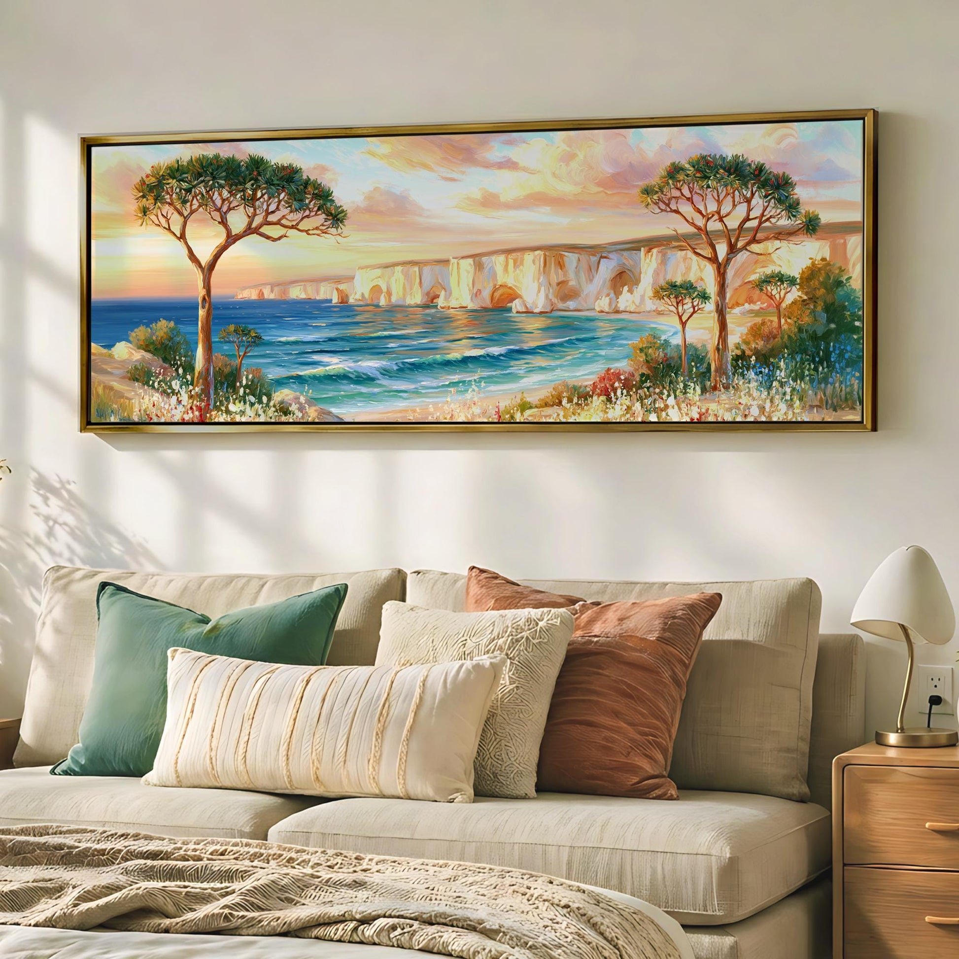 a large painting of a scenic landscape hanging on a wall above a beige sofa with colorful throw pillows.
