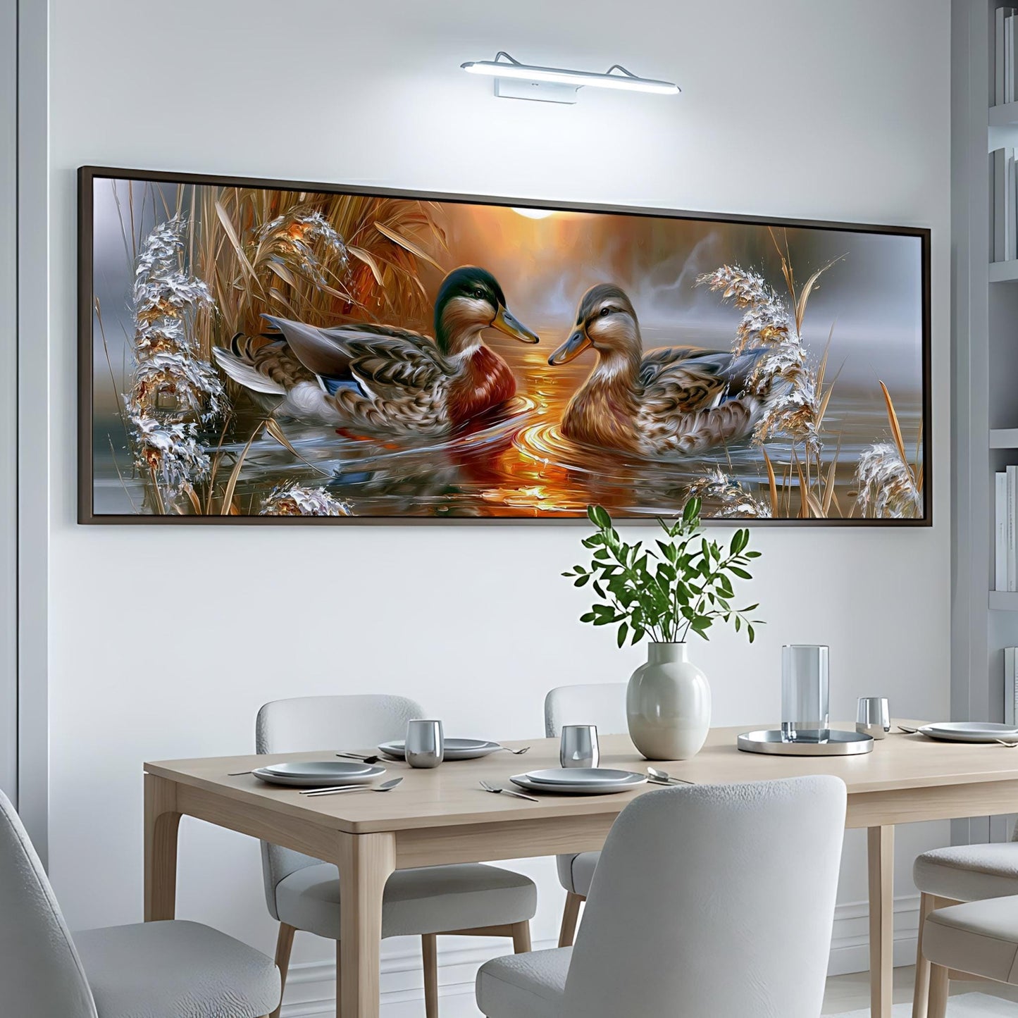 a large painting of ducks swimming in a pond, hanging on a white wall above a wooden dining table.