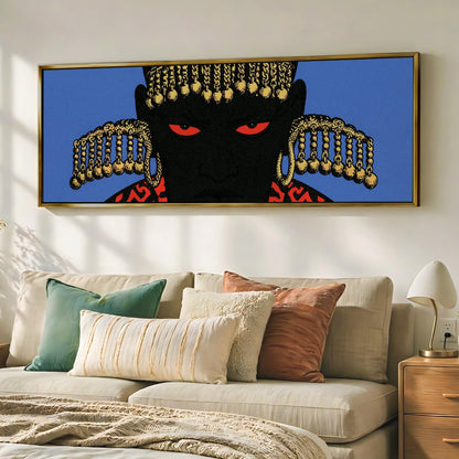 a large framed artwork depicting a black figure with red eyes and gold ornaments, hanging on a wall above a beige couch with various pillows.