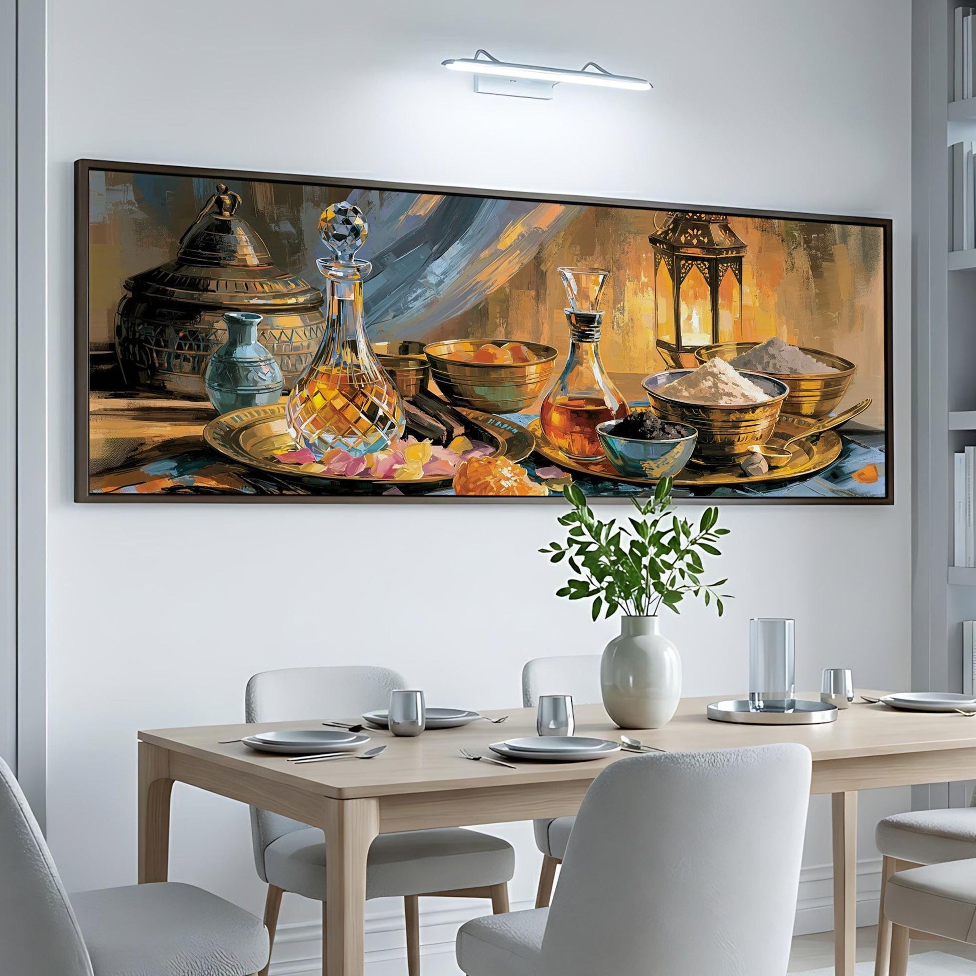 a large painting of a table set with various dishes and glassware, including bottles, bowls, and a vase, hanging on a white wall above a wooden dining table.