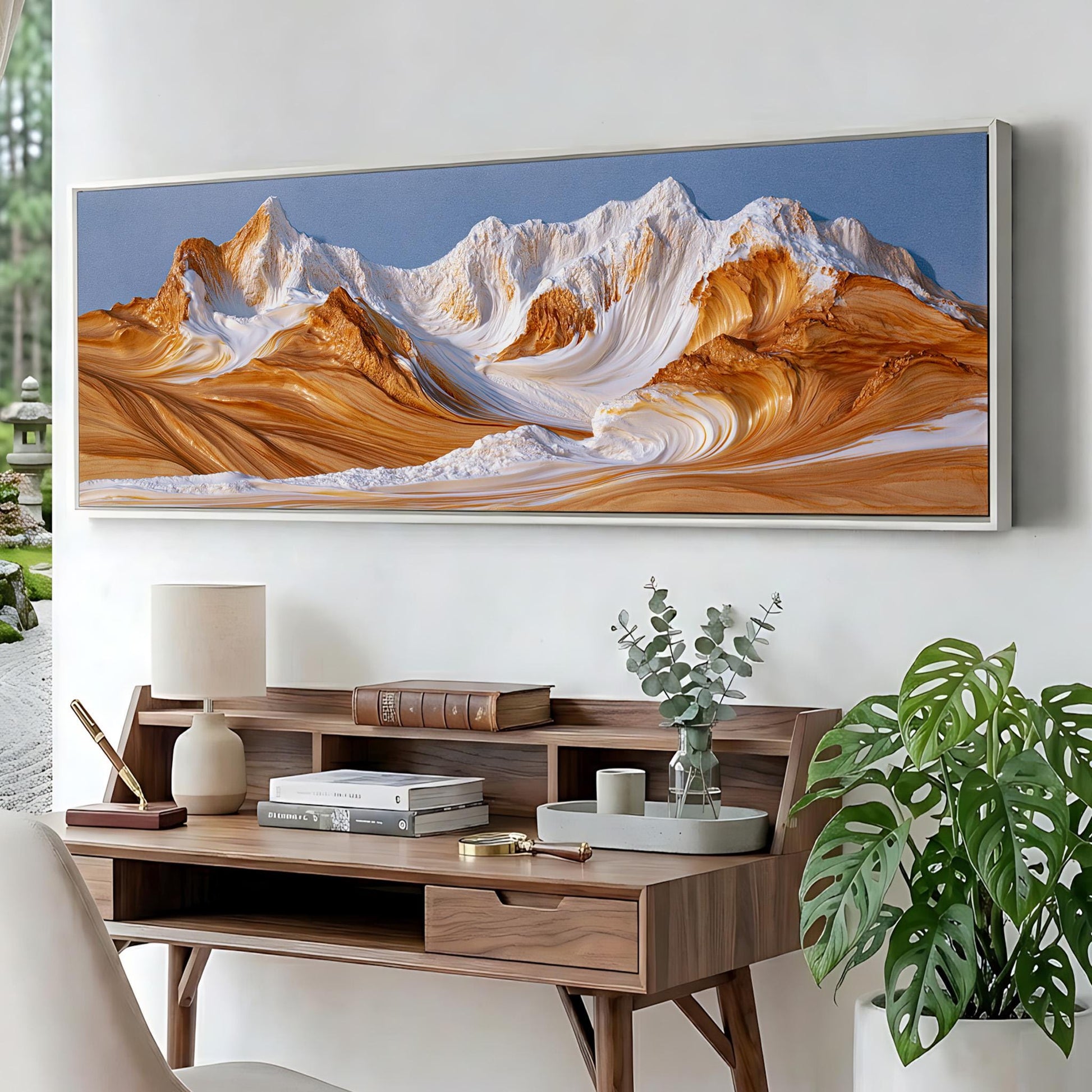 a large, colorful painting of a mountain landscape hanging on a wall above a wooden desk with various items on it.