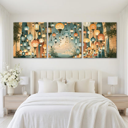 a large bedroom with a white bed and nightstands. Above the bed, there is a large wall art display with three panels depicting a scene of hanging lanterns in various colors and sizes.