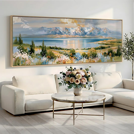 a large landscape painting hanging on a wall above a white sofa and a round coffee table with a vase of flowers.