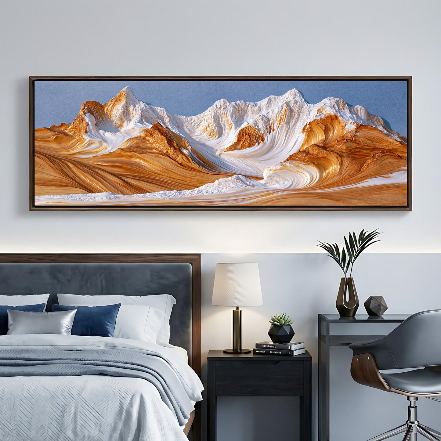 a large, framed landscape painting depicting a mountain range with a blue sky and orange and white peaks. The painting is hanging on a wall above a bed with a gray headboard.