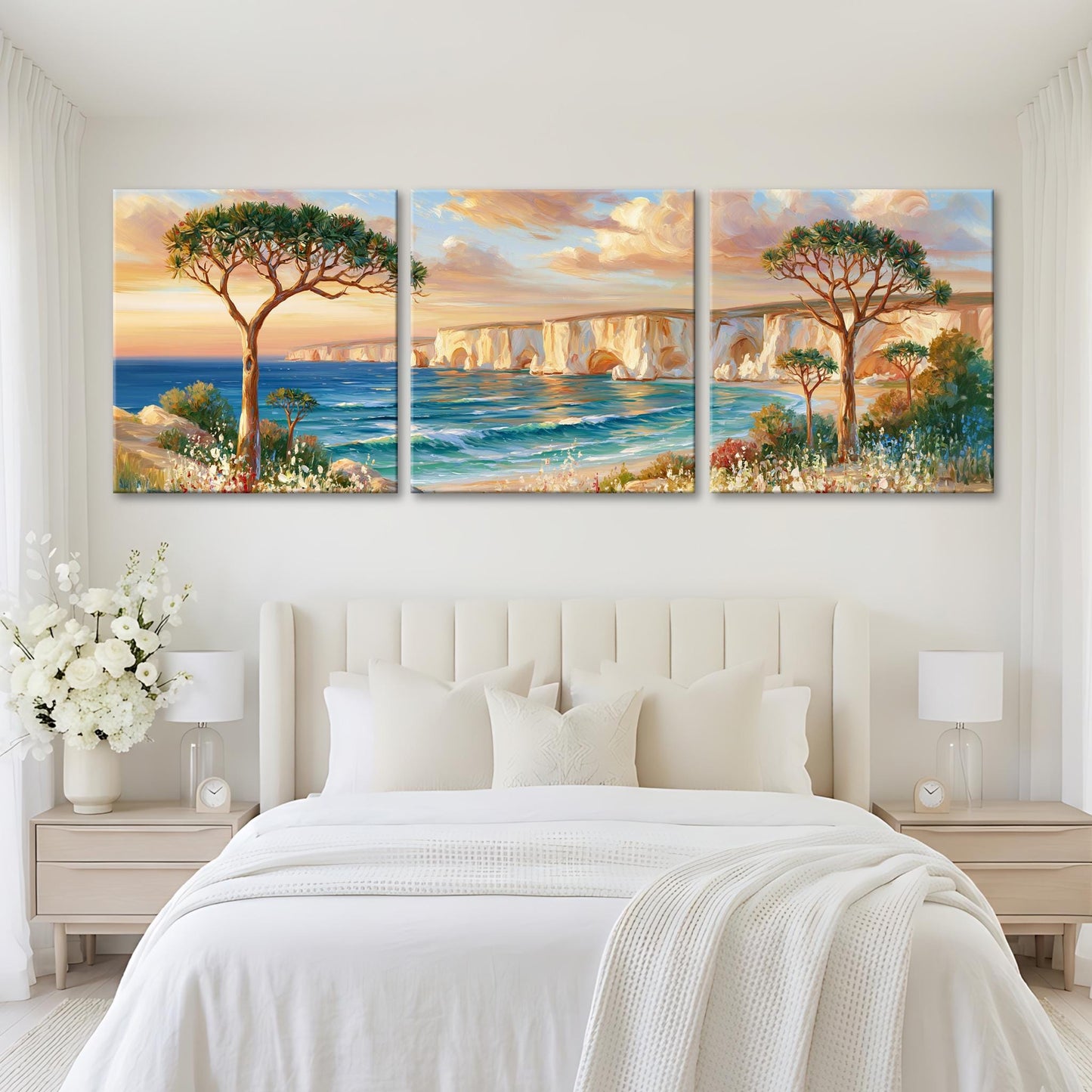a serene bedroom setting with a large bed, white bedding, and a painting of a scenic landscape above it. The painting depicts a picturesque coastal scene with a tree, a bridge, and the ocean.