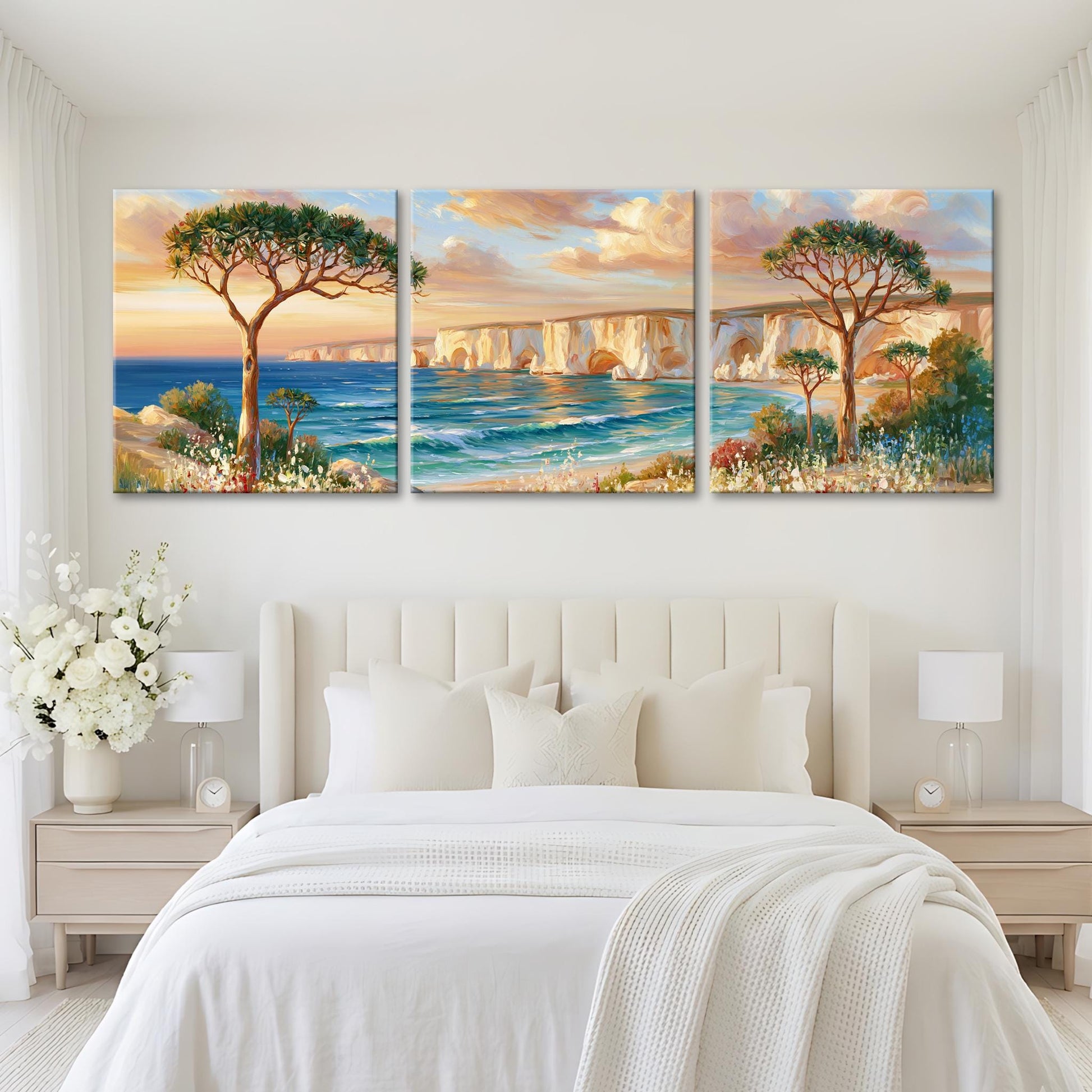 a serene bedroom setting with a large bed, white bedding, and a painting of a scenic landscape above it. The painting depicts a picturesque coastal scene with a tree, a bridge, and the ocean.