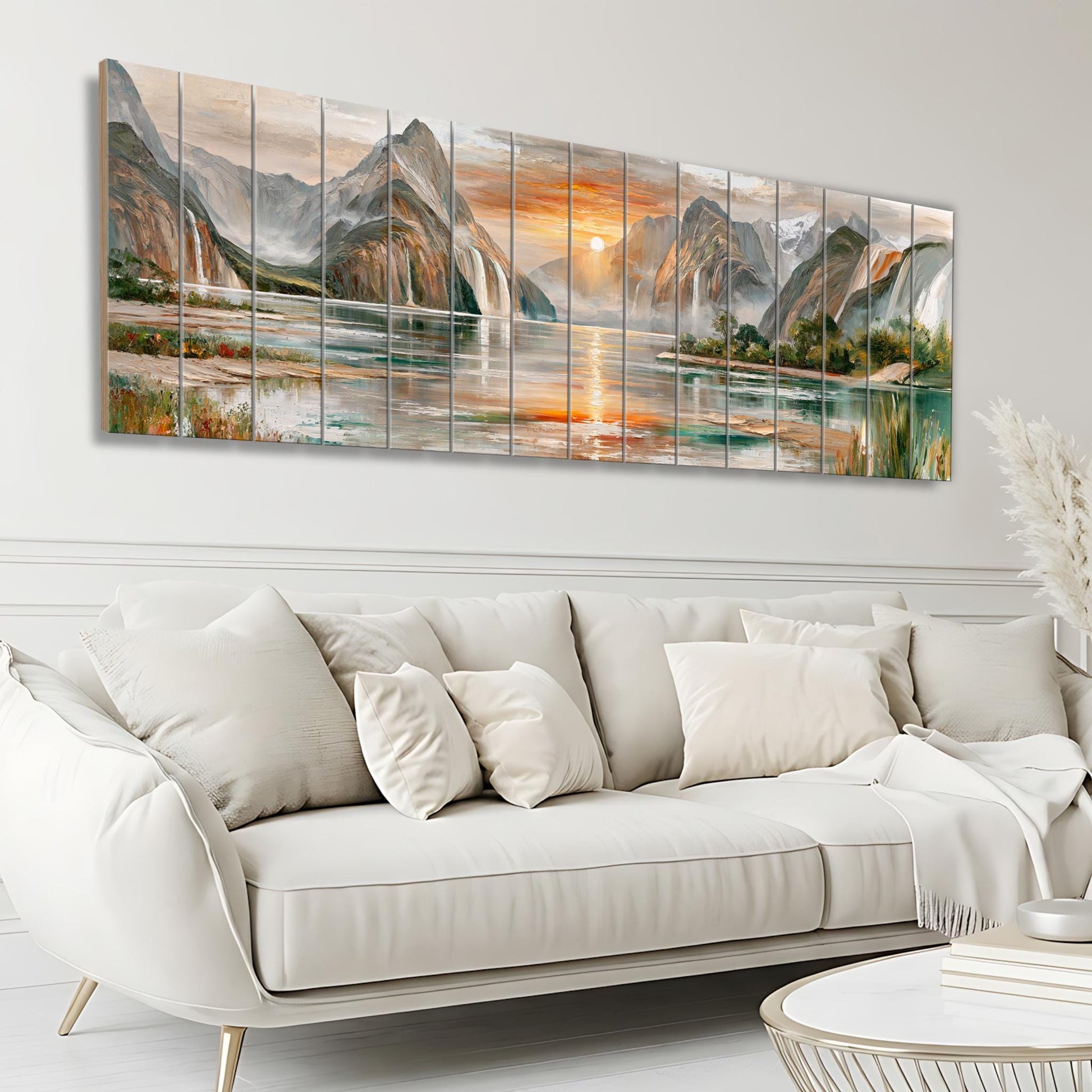 a large, white, leather couch with multiple pillows, situated in a living room setting. Above the couch, there is a large, colorful painting depicting a scenic landscape with mountains, water, and a sunset.