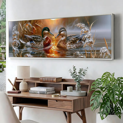 a large painting of ducks swimming in a pond, hanging on a wall above a wooden desk with various items on it.