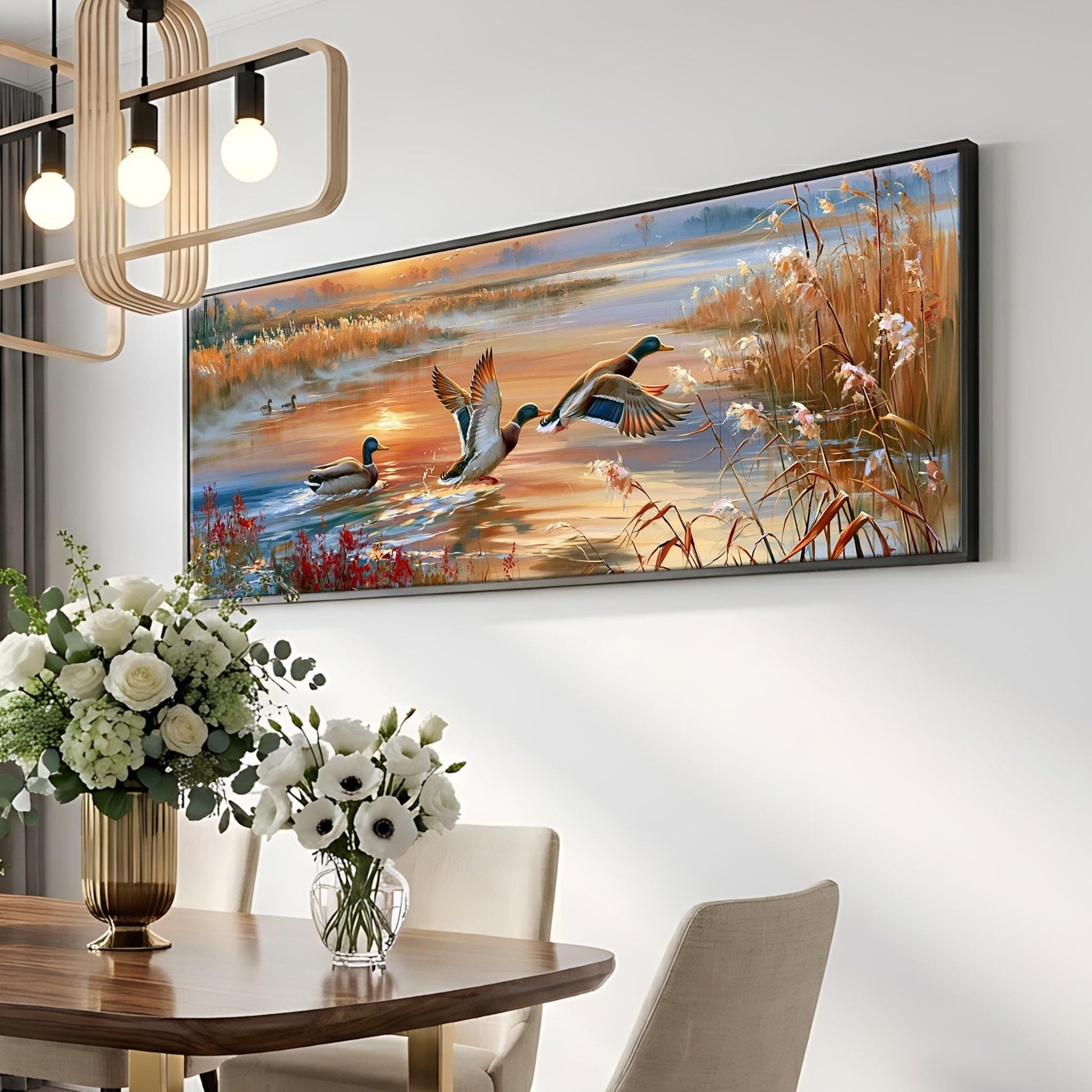 a large painting of ducks swimming in a pond, hanging on a wall above a dining table with a vase of flowers.