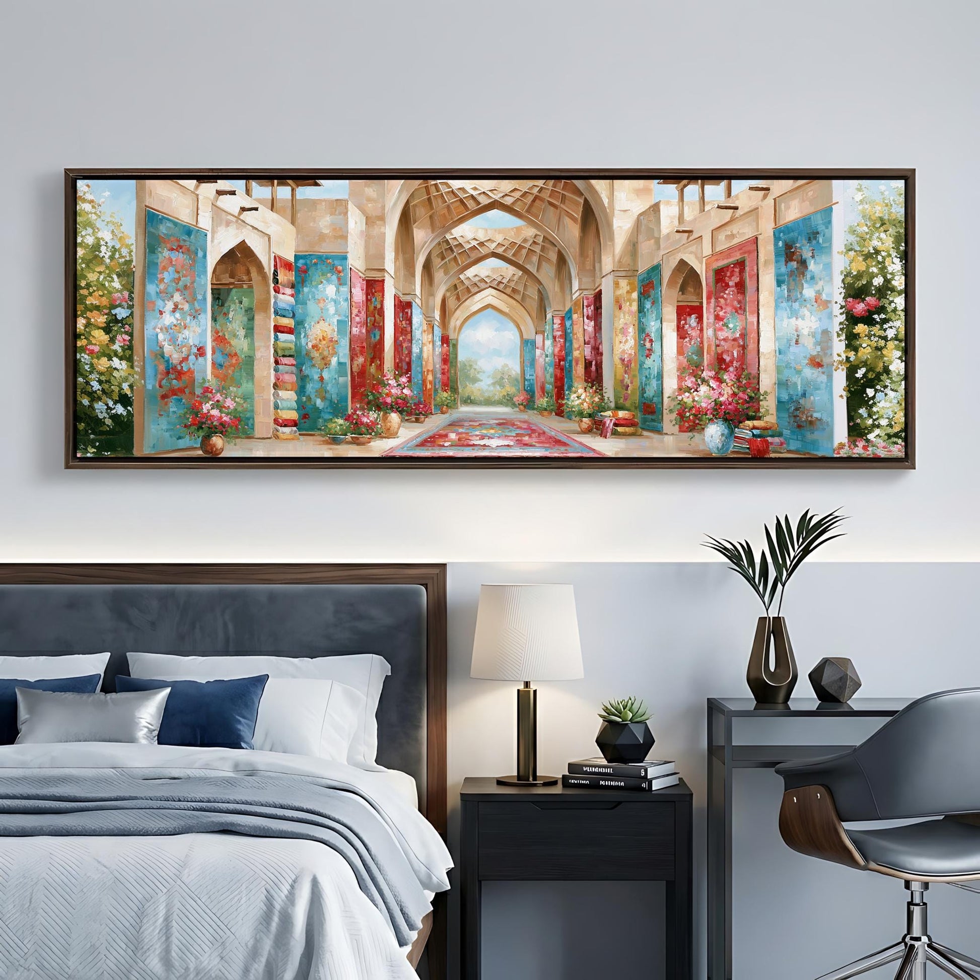 a large, colorful painting of an ornate, arched hallway with floral decorations hanging from the walls. The painting is displayed on a wall above a bed with a gray headboard. The room also includes a nightstand with a lamp, a chair, and a small table with decorative items.