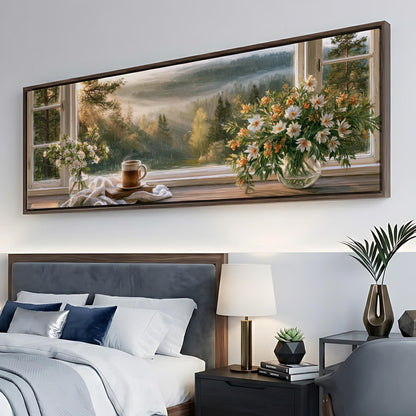 a large painting of a scenic landscape hanging on a wall above a bed with a view of a forest through a window.