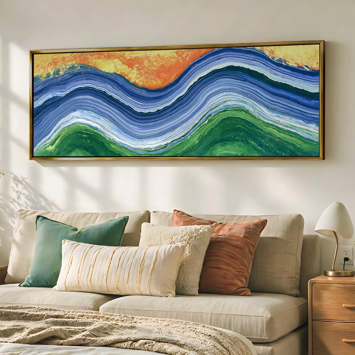 a large, colorful abstract painting hanging on a wall above a beige couch with various throw pillows.