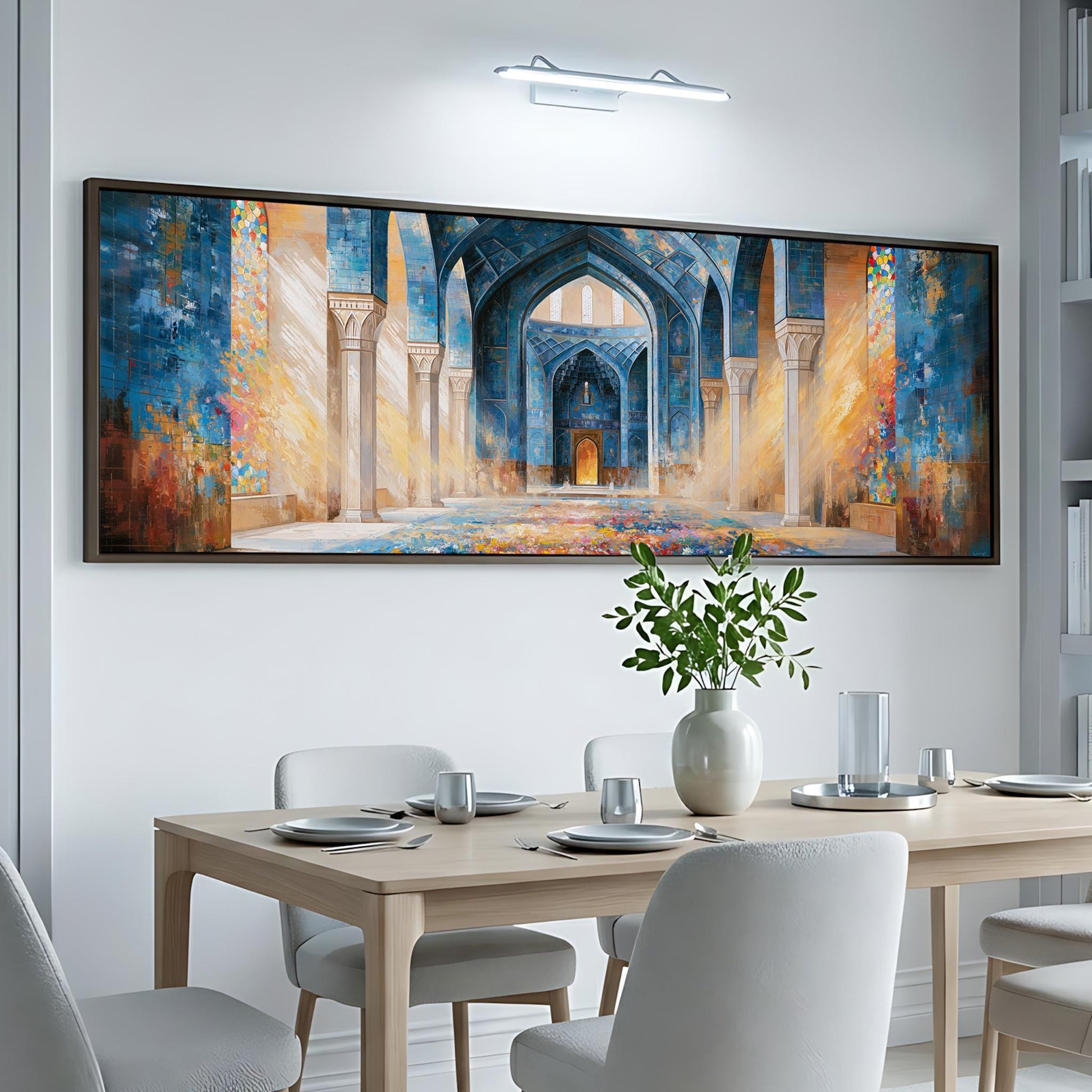 a large, colorful painting of an ornate, blue-tiled interior with arches and columns, hanging on a white wall above a wooden dining table set with plates, silverware, and a vase of flowers.