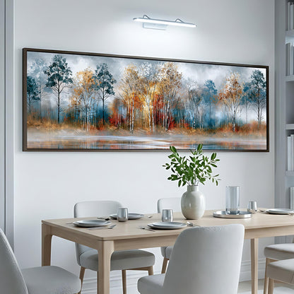 a dining room with a large, framed painting of a forest landscape hanging on the wall above a table set for a meal.