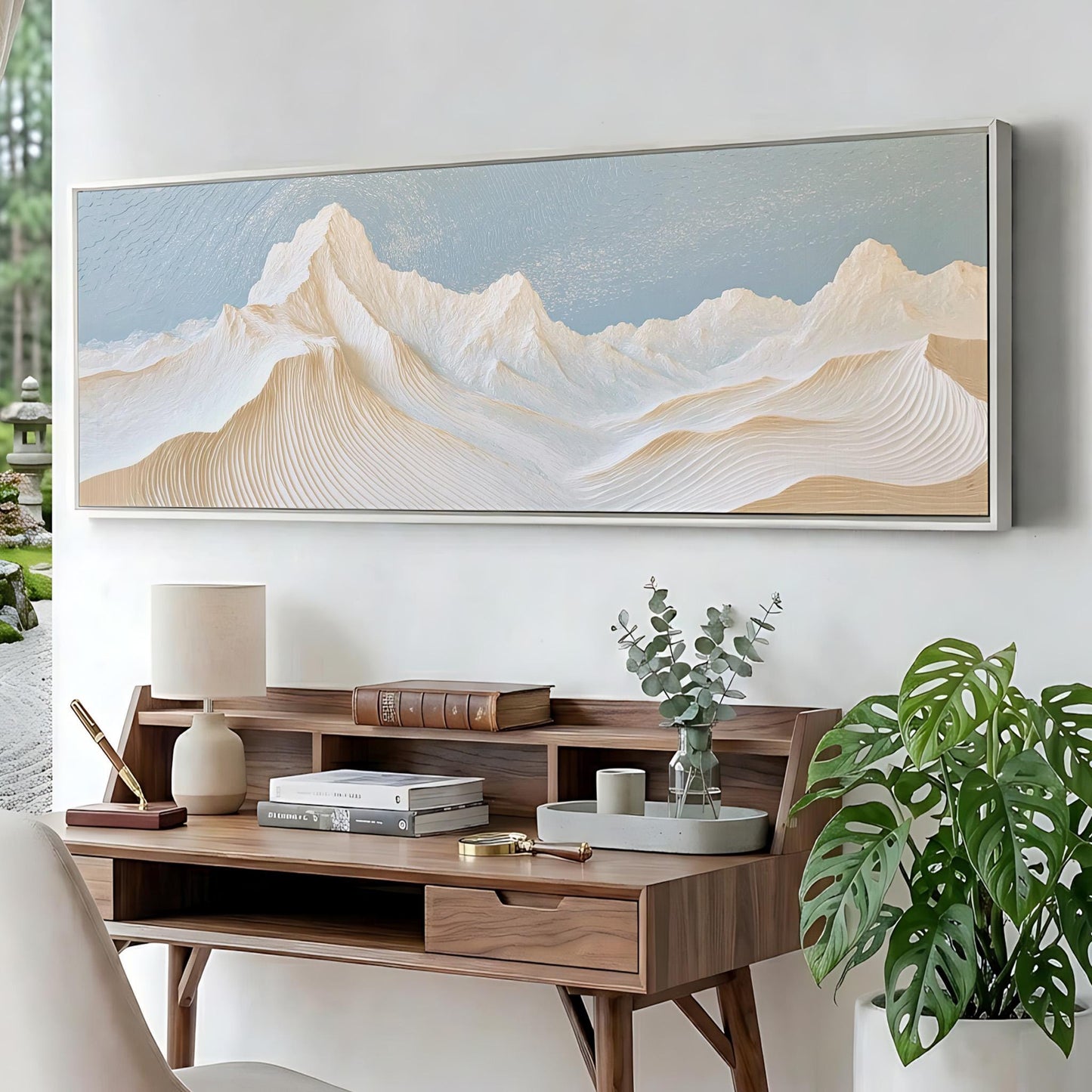 a wooden desk with a lamp, books, and a plant, set against a backdrop of a large landscape painting depicting a mountain range.