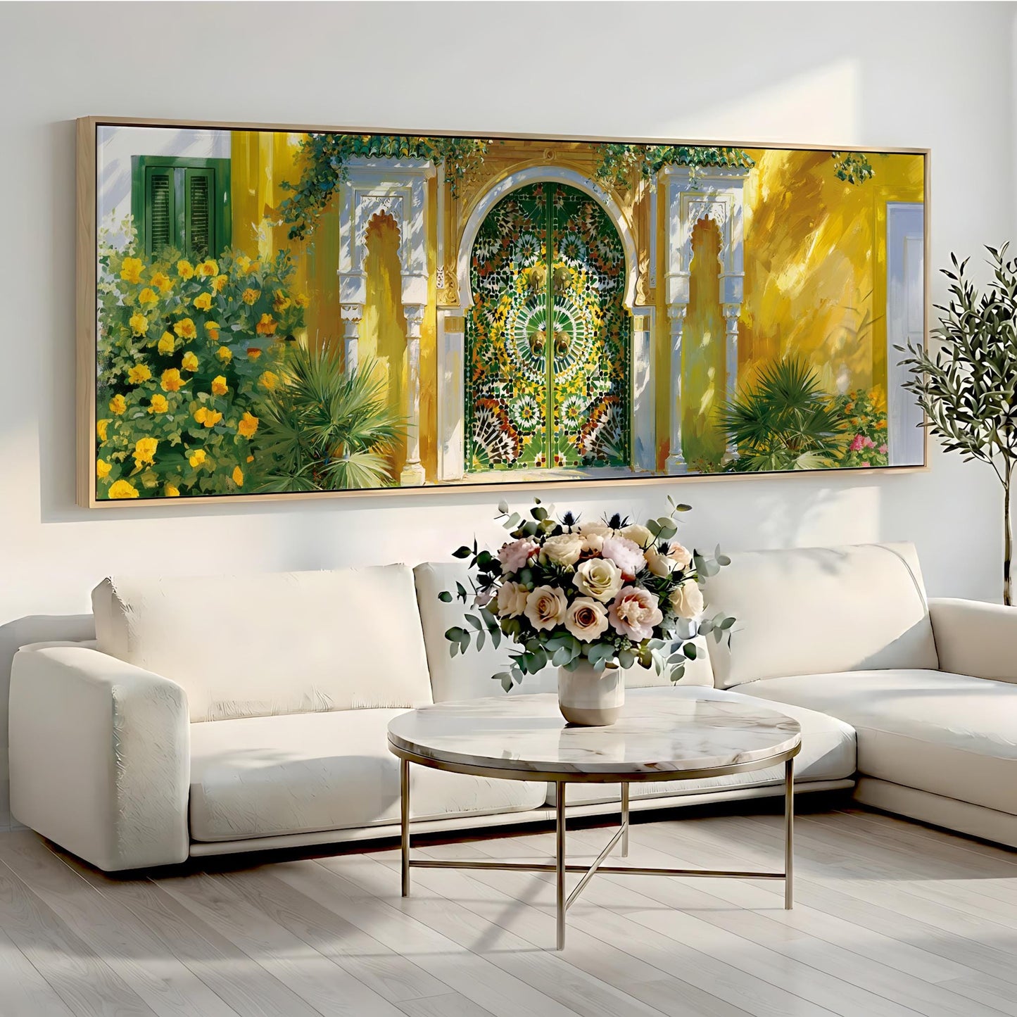 a large, colorful painting of a yellow building with a green door and arches, hanging on a wall above a white sofa and a round coffee table with a vase of flowers.