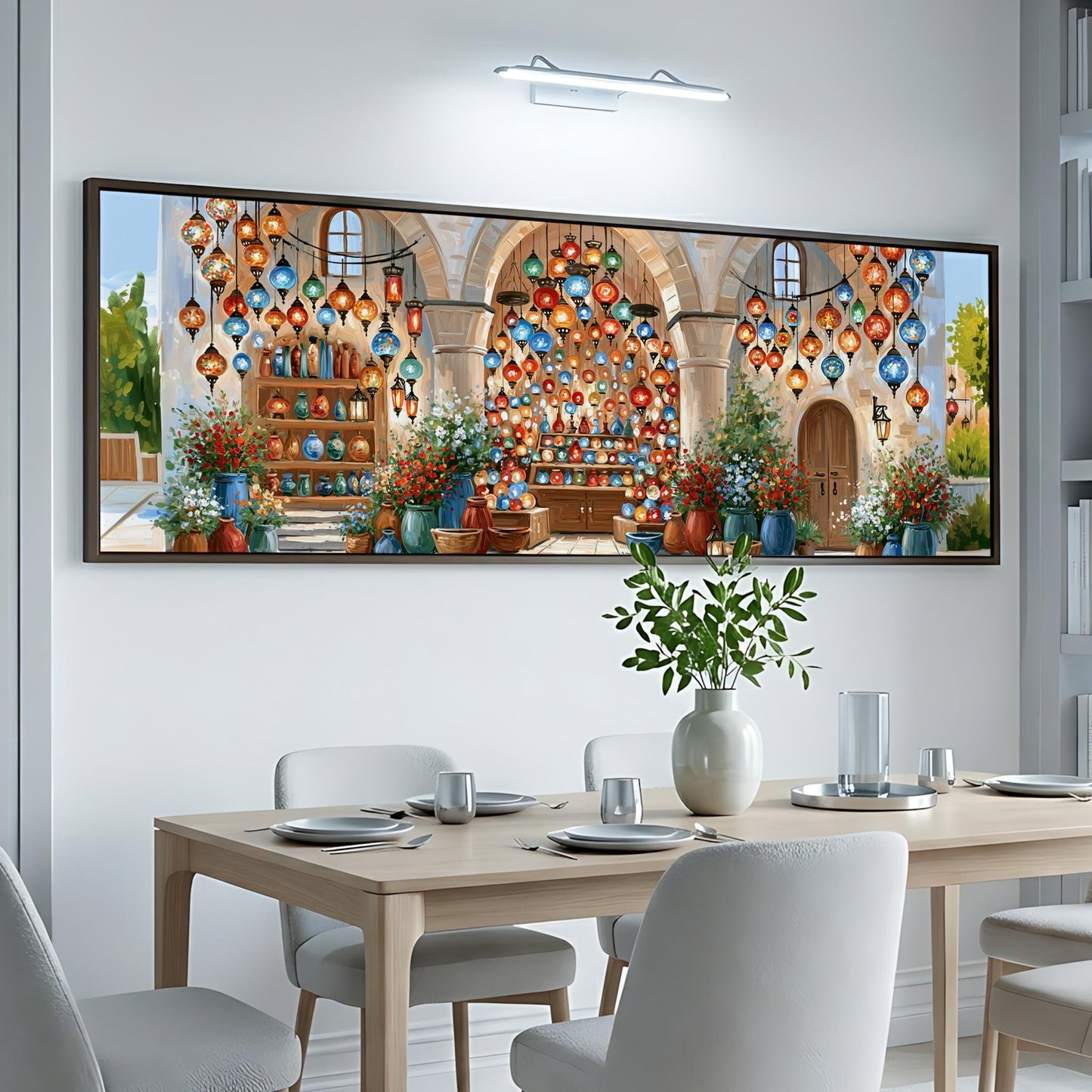 a dining room with a large, colorful painting of a building and lanterns hanging above a table set for a meal.