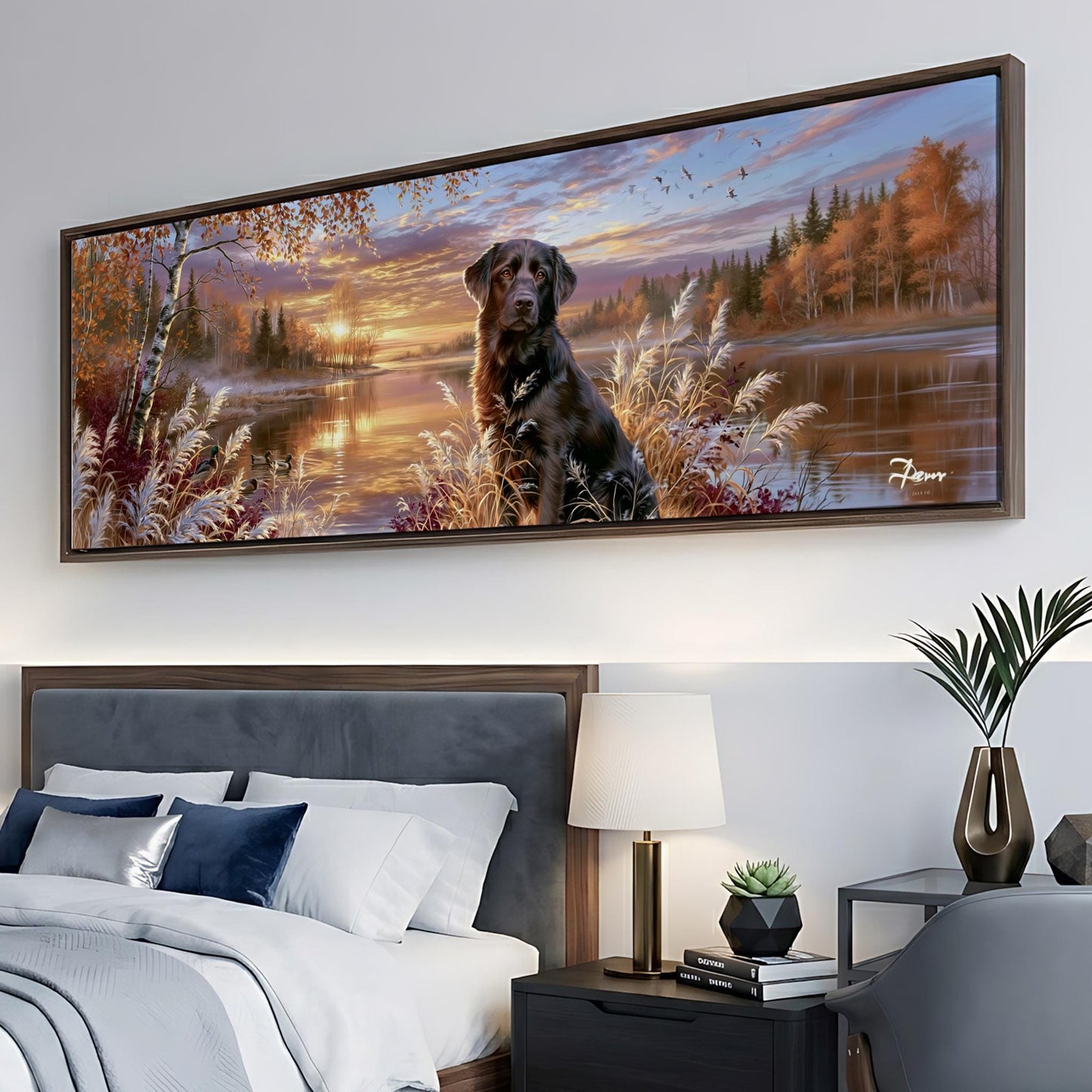 A large framed painting depicting a black dog sitting in a field with trees and a sunset in the background, hanging on a wall above a bed with a gray headboard.
