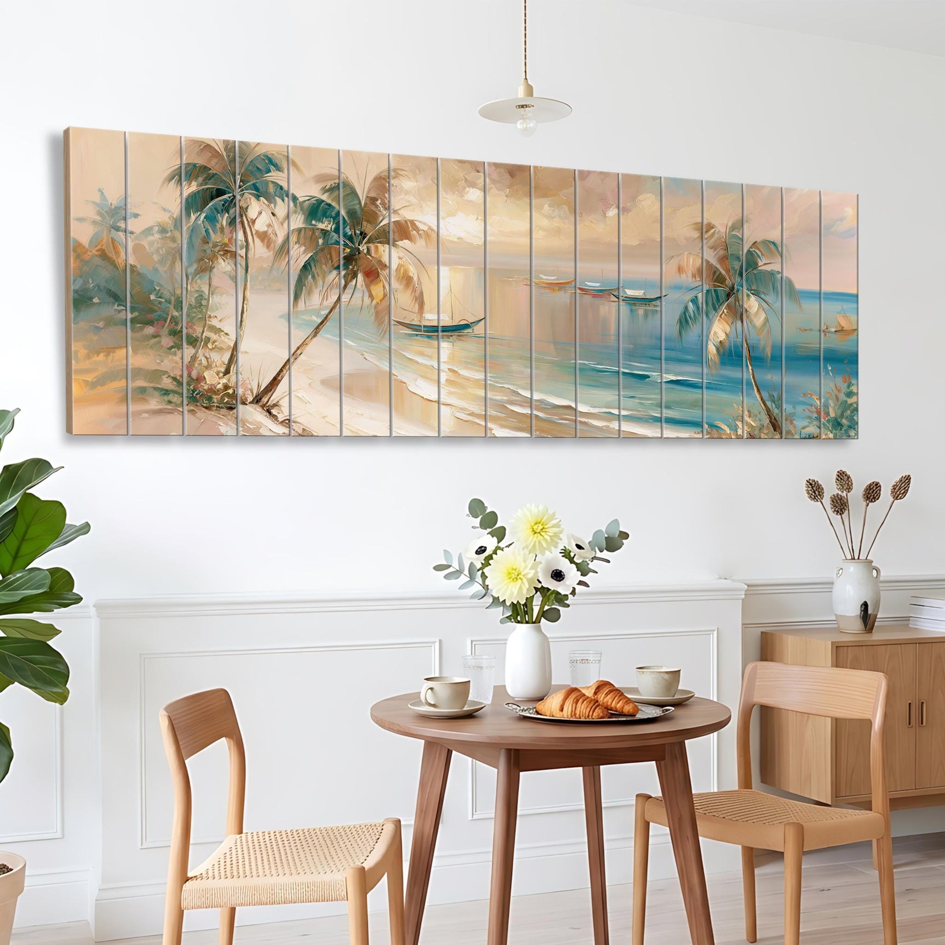 a dining area with a table set for two, featuring a vase of flowers, a plate of pastries, and two chairs. Above the table, there is a large painting depicting a tropical beach scene with palm trees and a boat in the water.