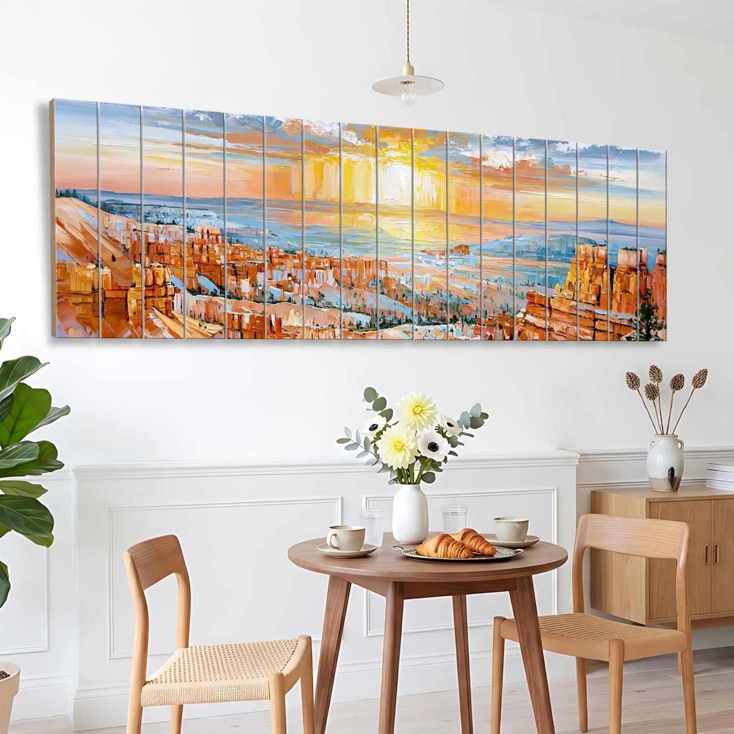 a dining area with a wooden table, two chairs, and a vase of flowers. Above the table, there is a large painting depicting a cityscape with a sunset in the background.