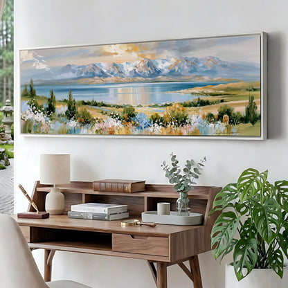 a large landscape painting hanging on a wall above a wooden desk with a lamp, books, and a vase of greenery.