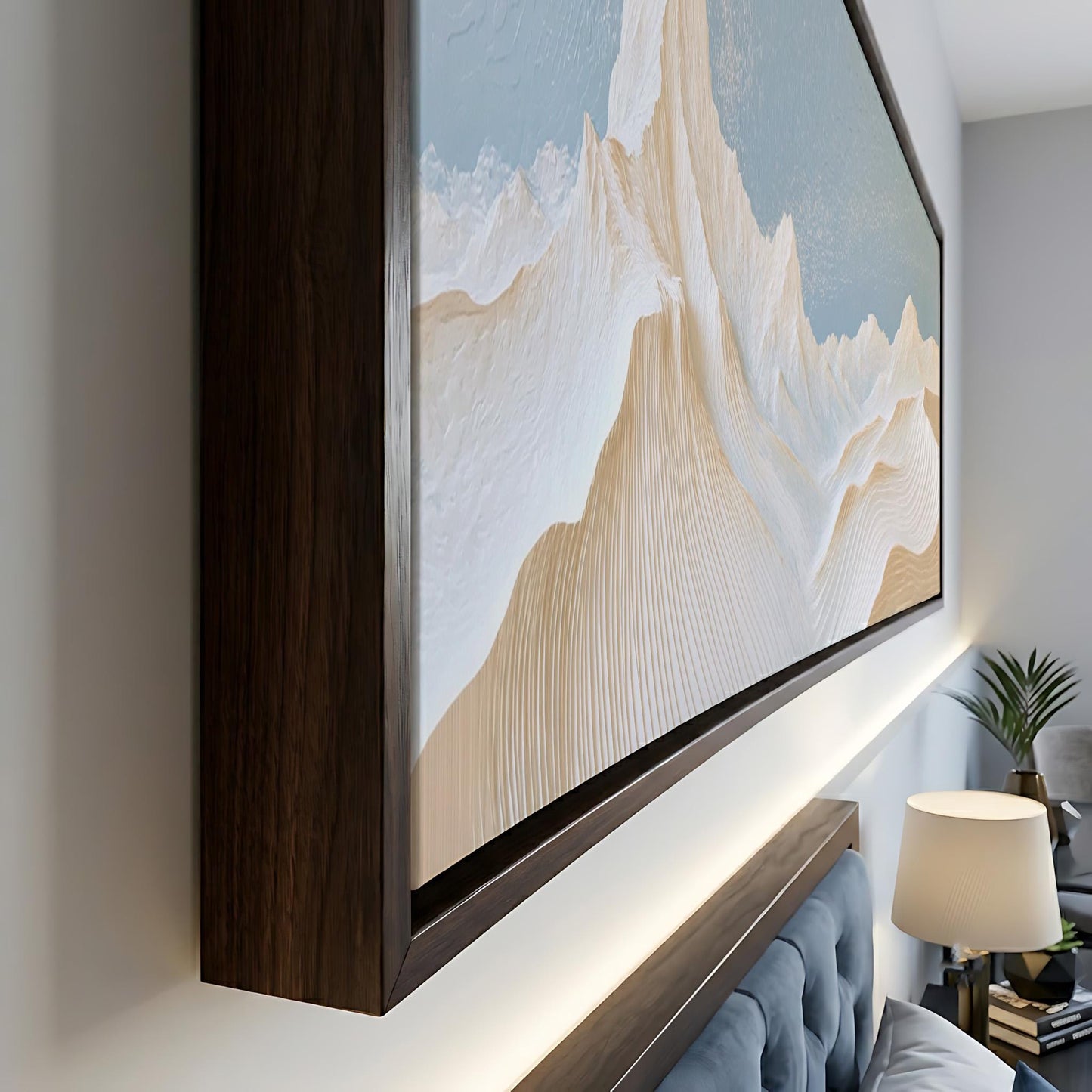 a large, framed painting of a mountain landscape hanging on a wall.