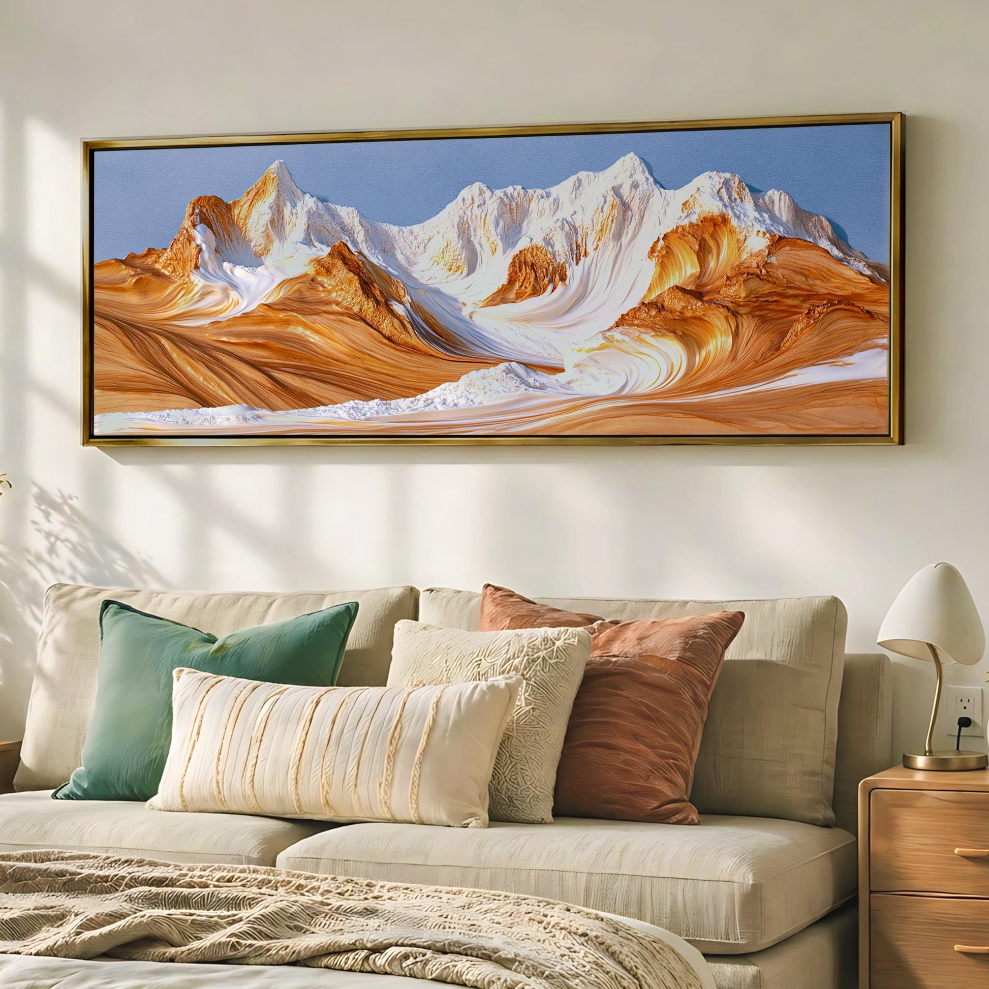 a large, framed painting of a mountain landscape hanging on a wall above a beige couch with colorful throw pillows.