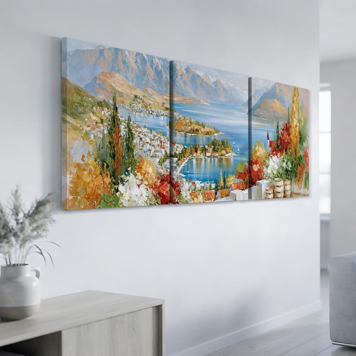a large, colorful painting of a scenic landscape with mountains, a lake, and a town in the background.