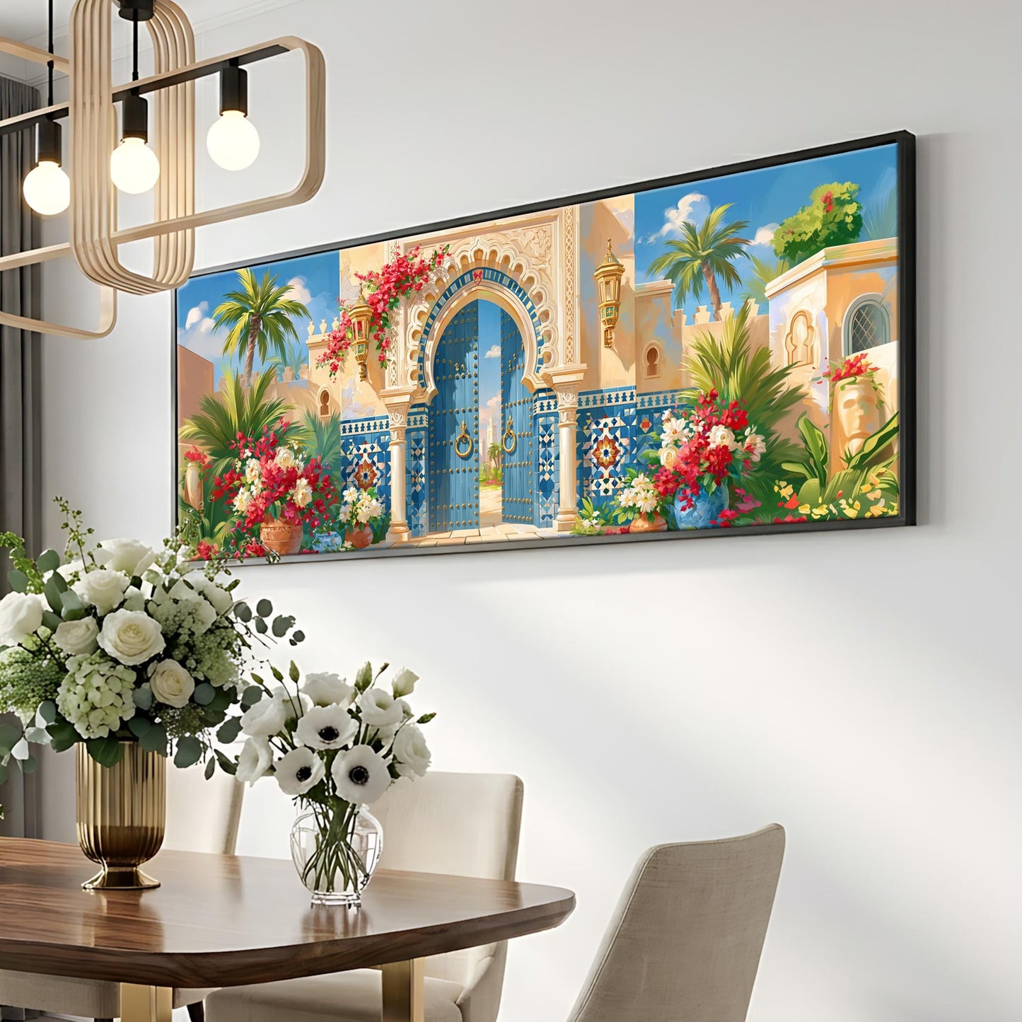 a large, colorful painting of an ornate, blue and yellow gate with a red archway, surrounded by tropical flowers and lush greenery. The painting is hung on a white wall above a wooden dining table with a vase of white flowers. The table is set with white chairs, and a chandelier hangs above the table, creating a warm and inviting atmosphere.