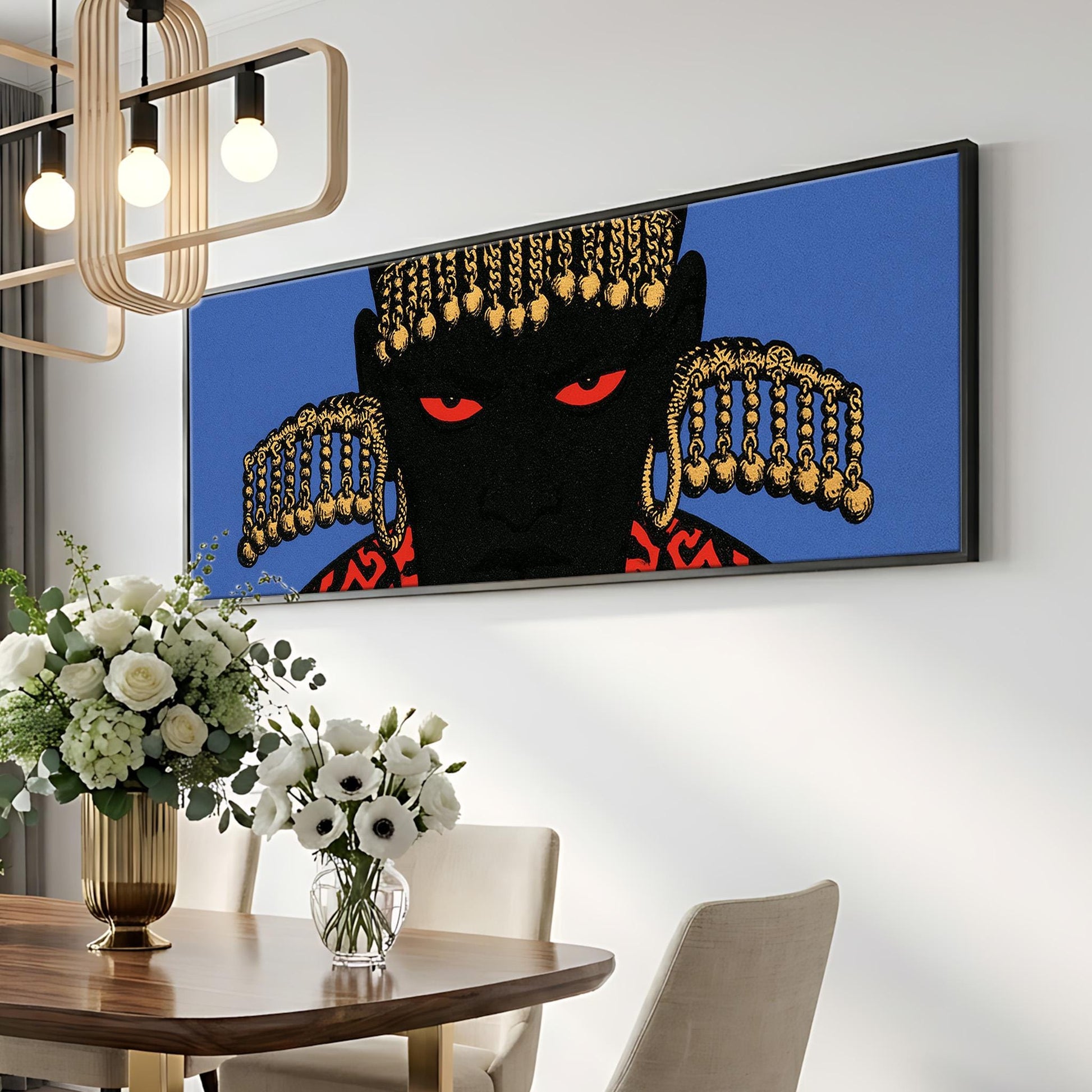 a dining room with a wooden table, a vase of white flowers, and a large framed artwork depicting a black figure with gold accents hanging on the wall above the table.