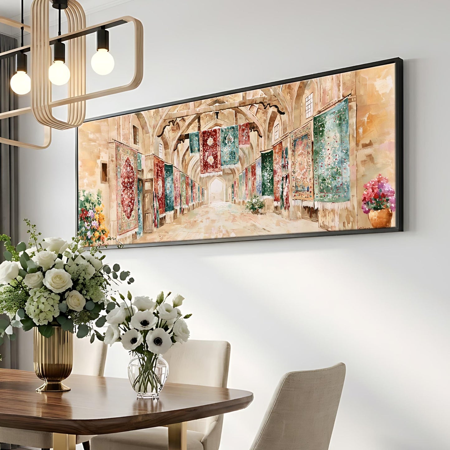a dining room with a large painting of a hallway on the wall above a wooden table with a vase of white flowers. The painting is framed in black and hangs above the table. The dining table is set with a vase of white flowers, and there are two chairs visible in the room.