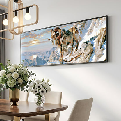 a large framed painting of a ram standing on a snowy mountain, hanging on a wall above a dining table with a vase of white flowers.